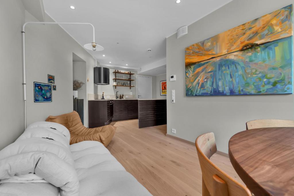 a living room with a table and a painting on the wall at Arctic Escape - Central Design Apartment in Tromsø