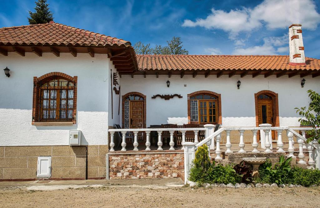 una casa blanca con techo rojo en La Viña, en Huertas de Pedrotello