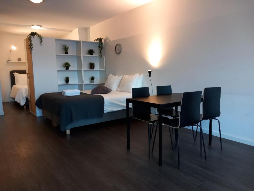 a bedroom with a bed and a table and chairs at Charming Retreat Apartment City 20Alpha in Delft