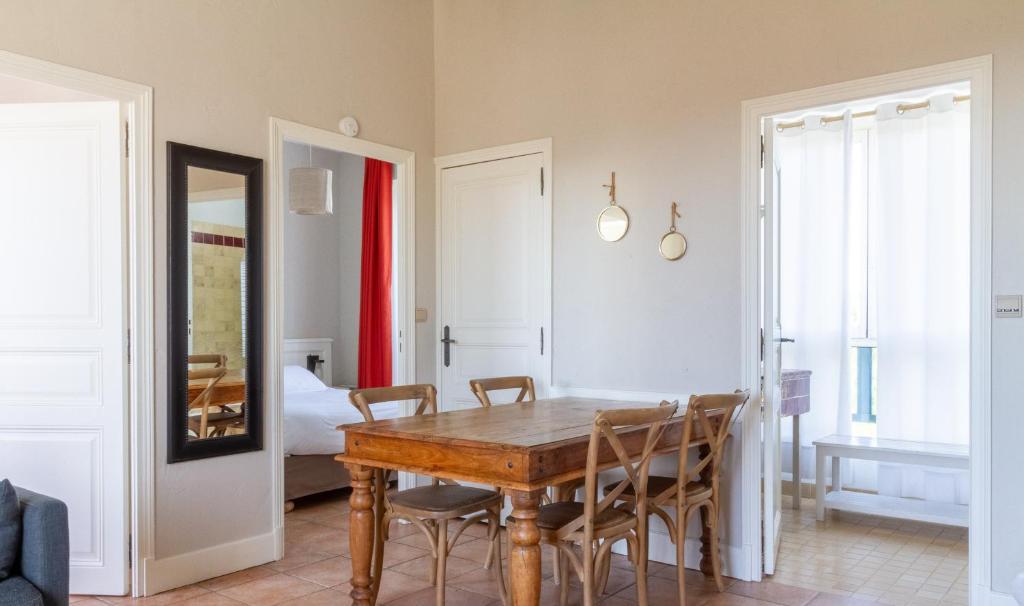 une salle à manger avec une table et des chaises en bois dans l'établissement Eco-Domaine La Fontaine - RESIDENCE-SPA - Plage de la Fontaine aux Bretons, à Pornic