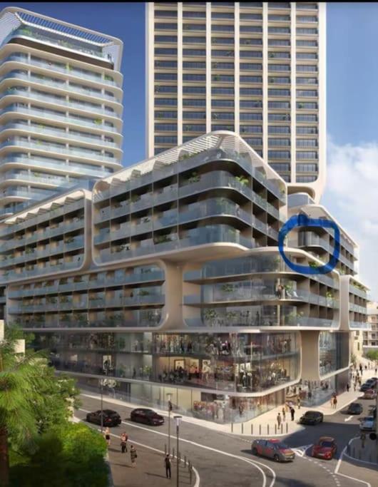 a large white building with a blue circle on it at Corner 1 Bed Apart in Mercury Suites with Rooftop Pool Seasonal in St. Julianʼs