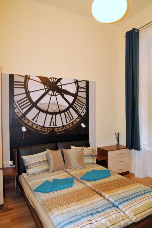 Hotel Frank & Fang Apartments, a bedroom with a large bed with a large clock on the wall at Frank & Fang Apartments in Budapest