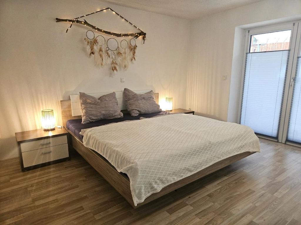 a bedroom with a large bed and a chandelier at Ferienwohnung im Alpenvorland am Lech in Apfeldorf
