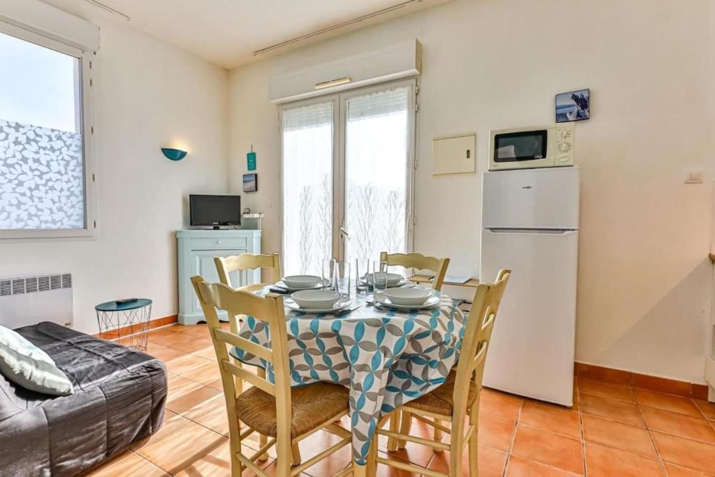 une cuisine et une salle à manger avec une table et des chaises dans l'établissement Apartment in residence with swimming pool and beach 200m away, à Saint-Jean-de-Monts