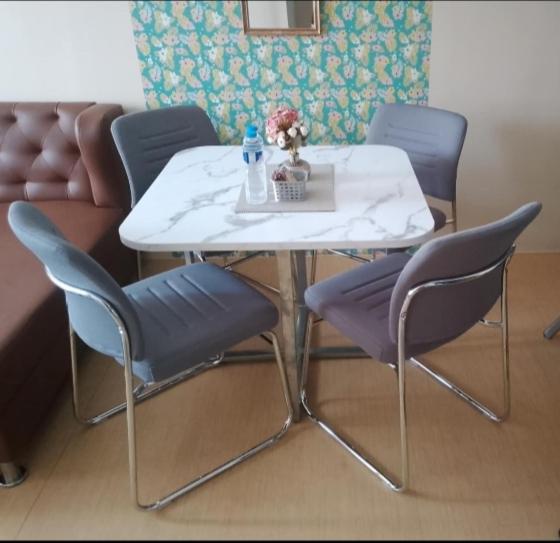 a table with purple chairs and a white table and chairs at Sunset Suite in Iloilo City