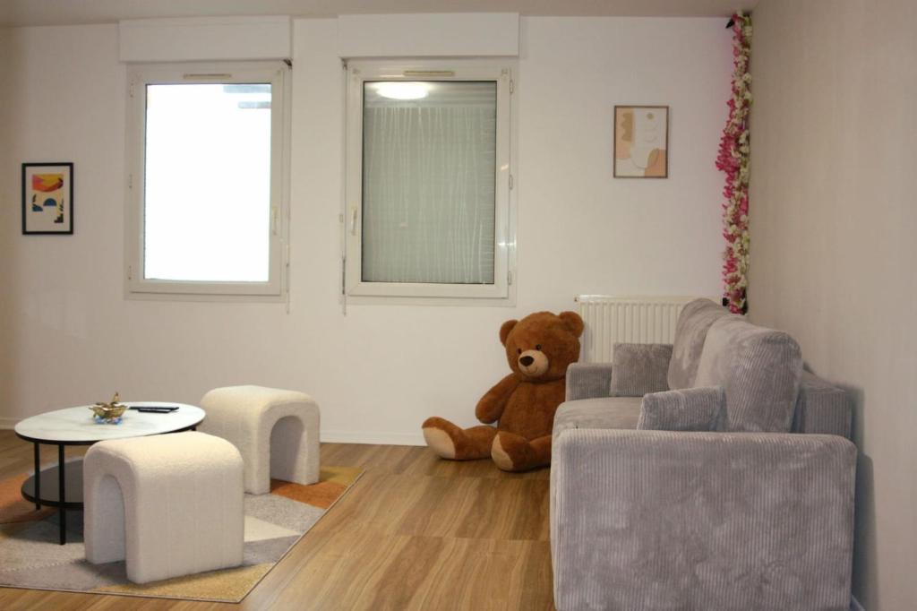 - un ours en peluche assis au sol dans le salon dans l'établissement Appartement Spacieux Domont 25 min Paris, à Domont