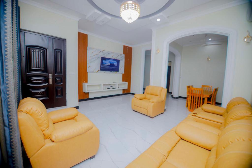 Una sala de estar con un sofá y dos sillas y un televisor. en Zanzibar home Residence, en Zanzíbar