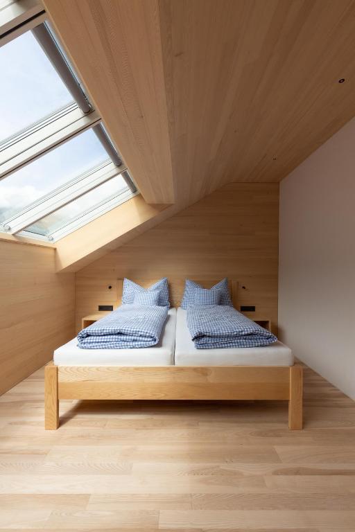 two beds in a room with a window at Beerenhus in Au im Bregenzerwald