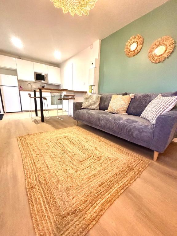 - un salon avec un canapé violet et un tapis dans l'établissement Appartement Chaleureux, à Laval