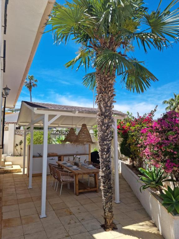 a patio with a table and a palm tree at Casa Marie - Albir in Albir