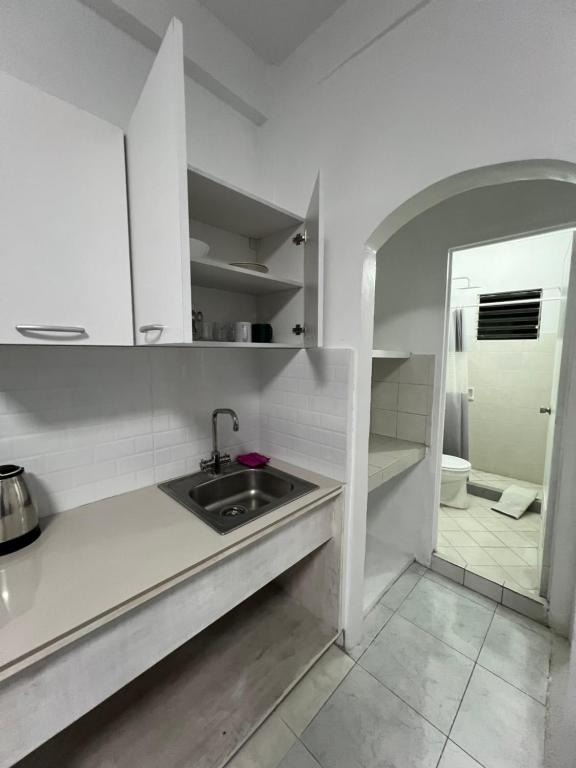 a white kitchen with a sink and a mirror at Bianco 305 in Angeles