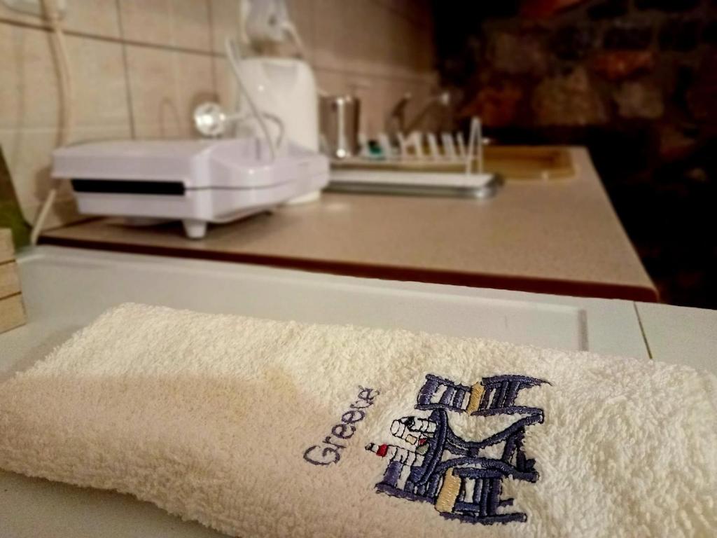 a towel on a kitchen counter with a sink at Kaimak Whisper in Palaios Agios Athanasios