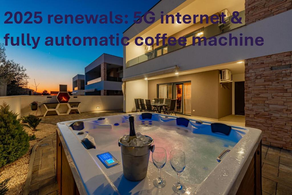 jacuzzi w ogródku z kieliszkami do wina w obiekcie Villa Elite w mieście Vir