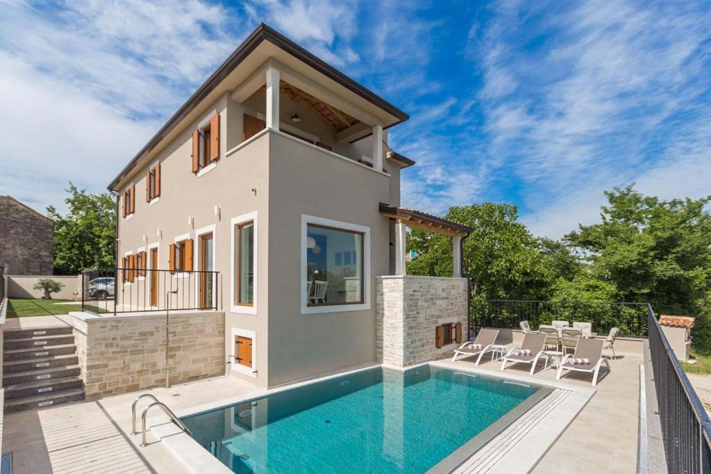 a villa with a swimming pool and a house at Villa Skarline in Donje Baredine