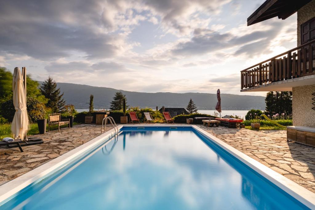 a swimming pool with a view of the mountains at Villa Manali - vue lac in Veyrier-du-Lac