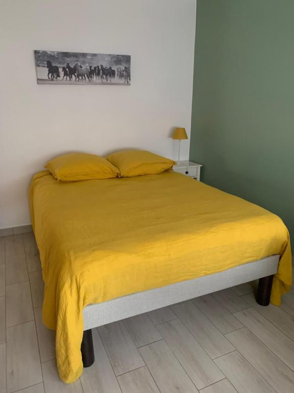 une chambre avec un lit avec une couverture jaune dans l'établissement T3 au centre-ville à Belfort, à Belfort