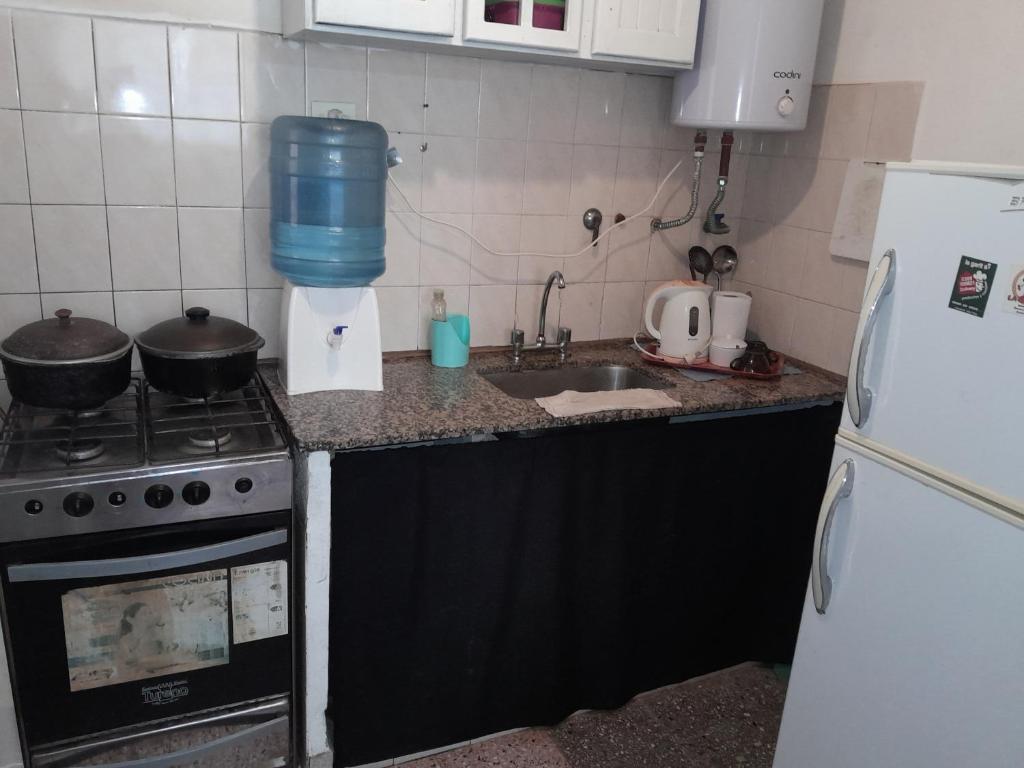 eine Küche mit einem Herd, einer Spüle und einem Kühlschrank in der Unterkunft Alojamiento Rivadavia in General Villegas