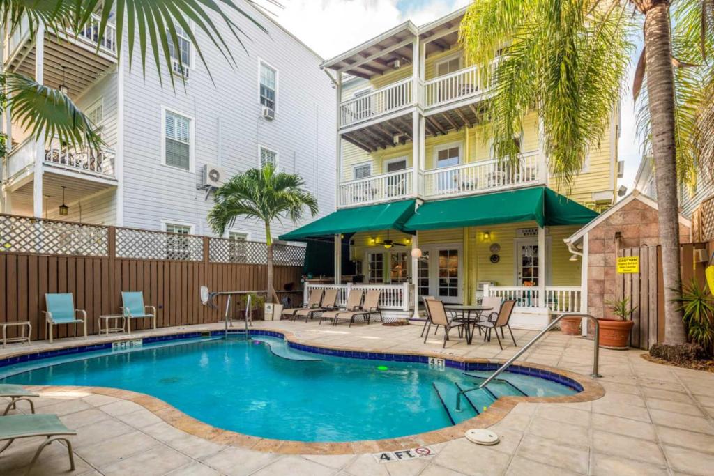 una piscina frente a un edificio con una casa en The Curry House - Entire Complex, en Key West