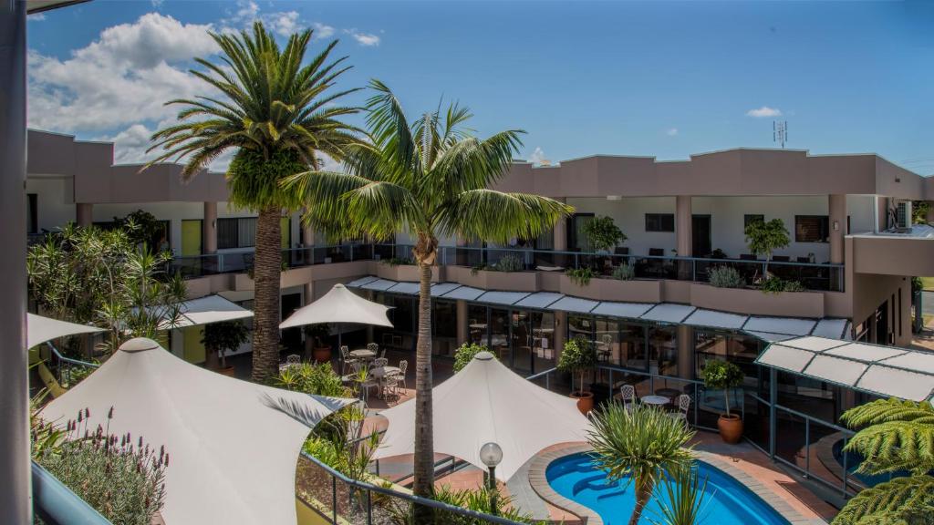 an aerial view of a hotel with a pool and palm trees at Rockpool Motor Inn in South West Rocks