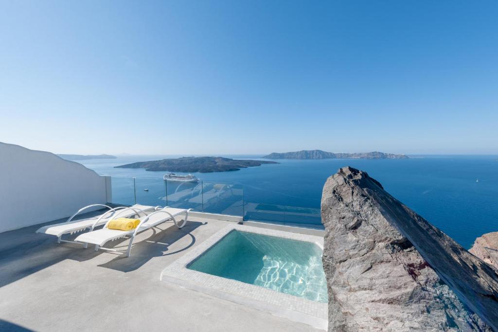 a swimming pool on the roof of a house with the ocean at Keti Hotel in Fira