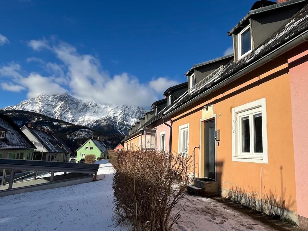 un edificio con una montaña cubierta de nieve en el fondo en Family Friendly Mountain House, en Eisenerz