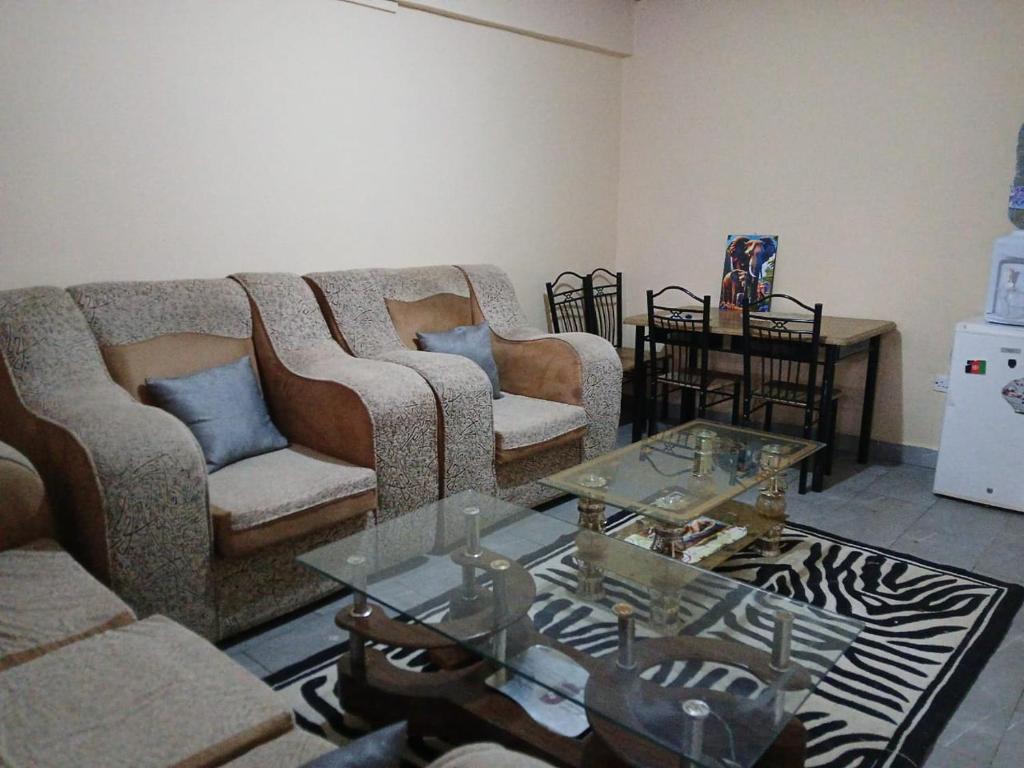 a living room with two couches and a table at Airbnb in Mwea town in Thiba