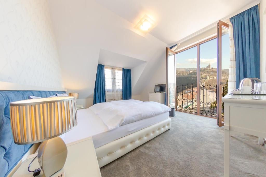 a bedroom with a bed and a large window at Hotel Studio in Veliko Tŭrnovo