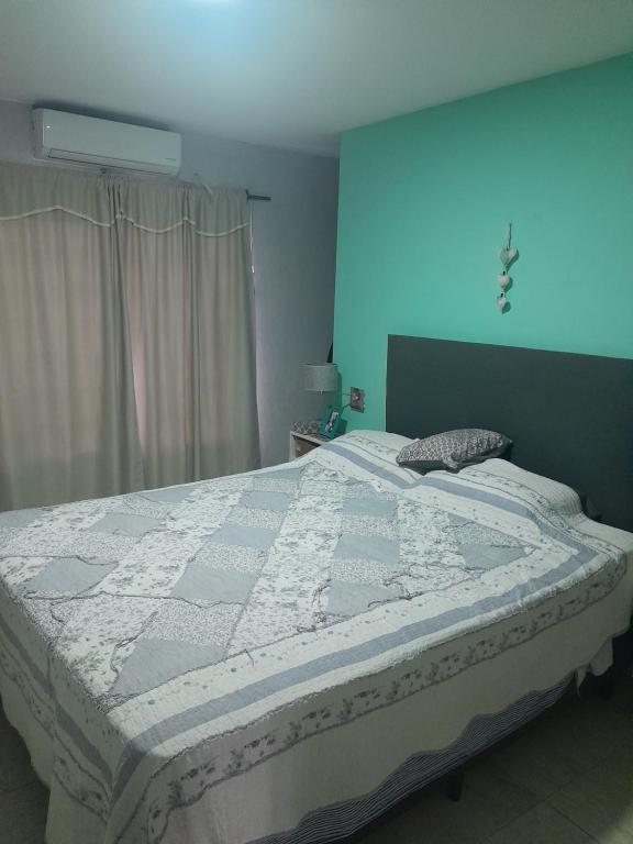 Un dormitorio con una cama grande con una pared azul. en Casa, en San Bernardo
