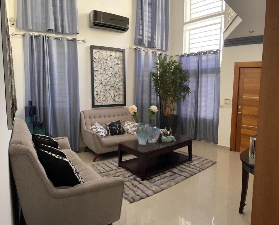 a living room with a couch and a coffee table at hermosa casa en las orquídeas la romana in La Romana