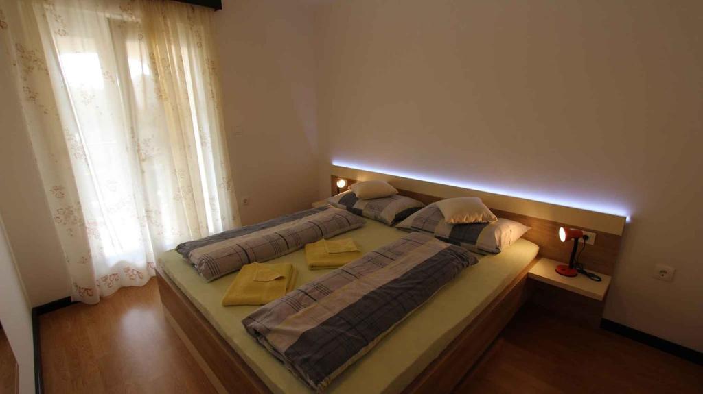 duże łóżko w pokoju z oknem w obiekcie Malinska Apartment 2 w mieście Sveti Anton