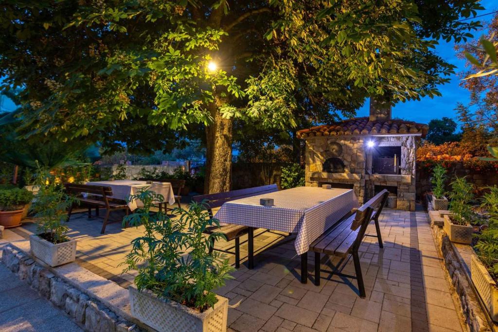 patio ze stołem, krzesłami i kominkiem w obiekcie Malinska Apartment 2 w mieście Sveti Anton