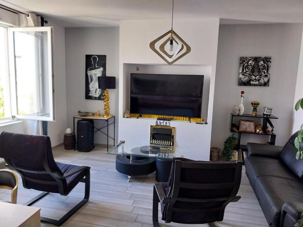 un salon avec un canapé et une télévision dans l'établissement Bienvenue, à Valence