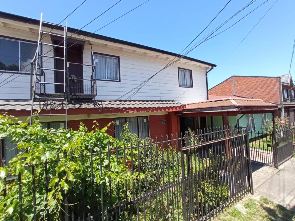 een huis met een hek ervoor bij Hospedaje Pensión Ely Habitación doble in Temuco