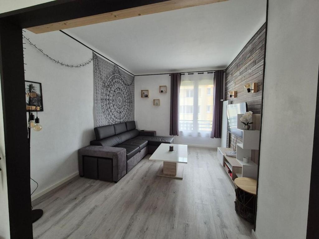un salon avec un canapé et une table dans l'établissement Appartement proche circuit 24h du Mans, au Mans