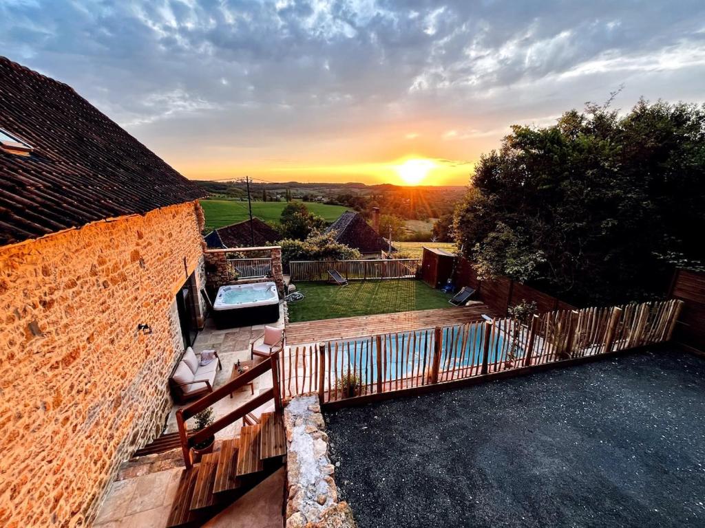 a view of the sunset from the backyard of a house at La Grange aux Souvenirs - Piscine chauffée ,Jacuzzi et Terrain de pétanque in Grèzes