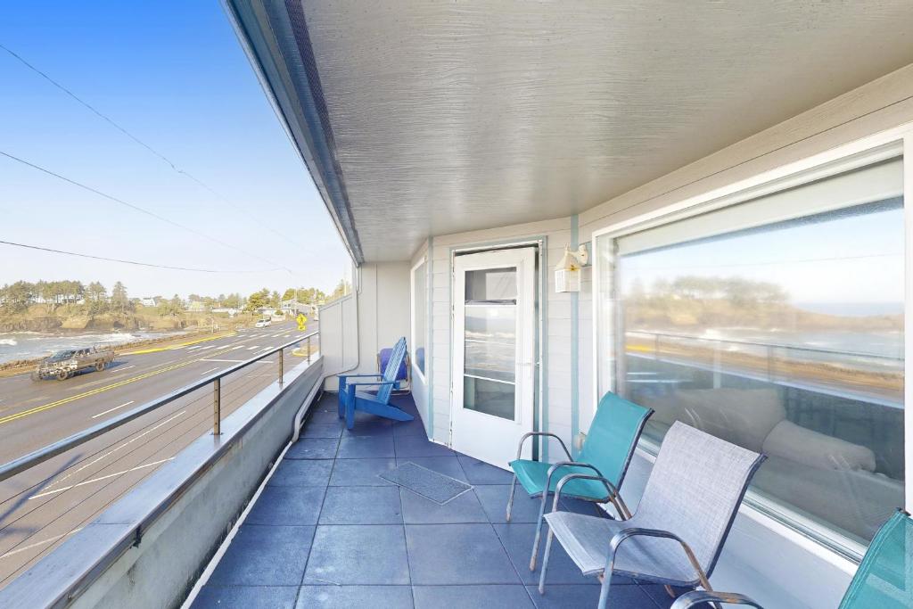 a balcony with chairs and a view of the highway at Whaler's Getaway in Depoe Bay