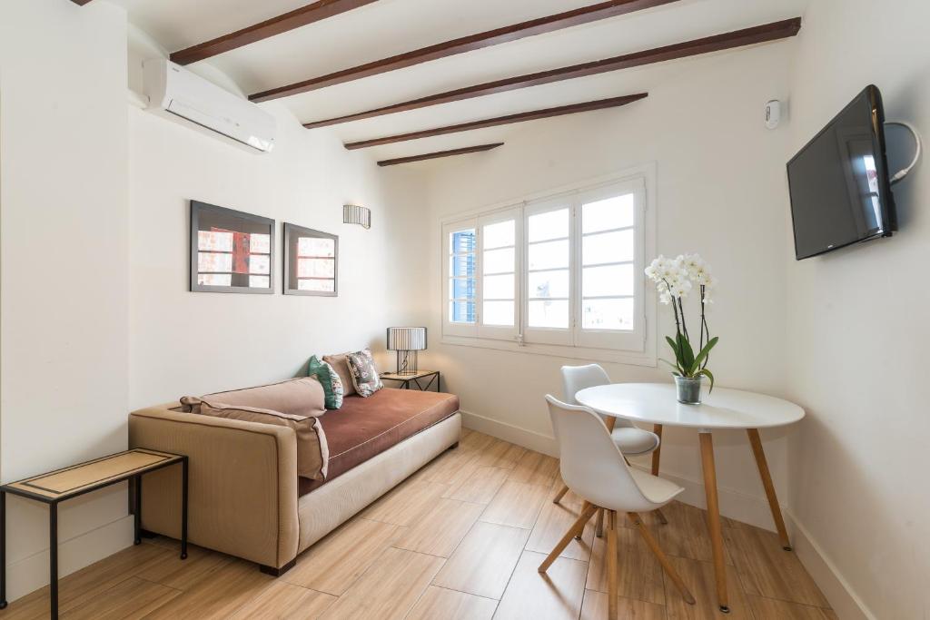 シッチェスにあるApartamentos Mayor by Habama Groupのベッドとテーブルのあるリビングルーム