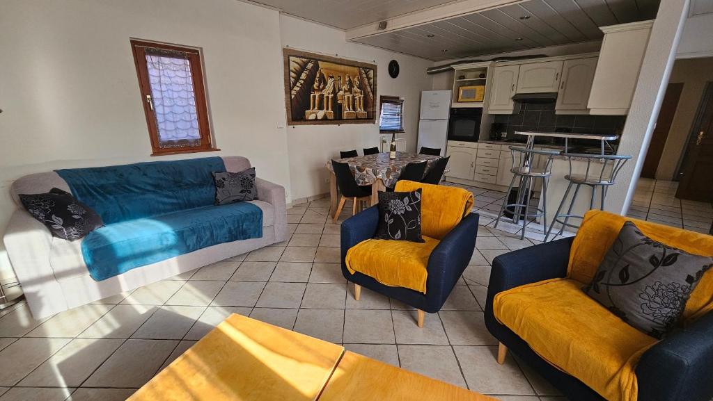 een woonkamer met een bank en stoelen en een keuken bij Chez Fretz in Ribeauvillé