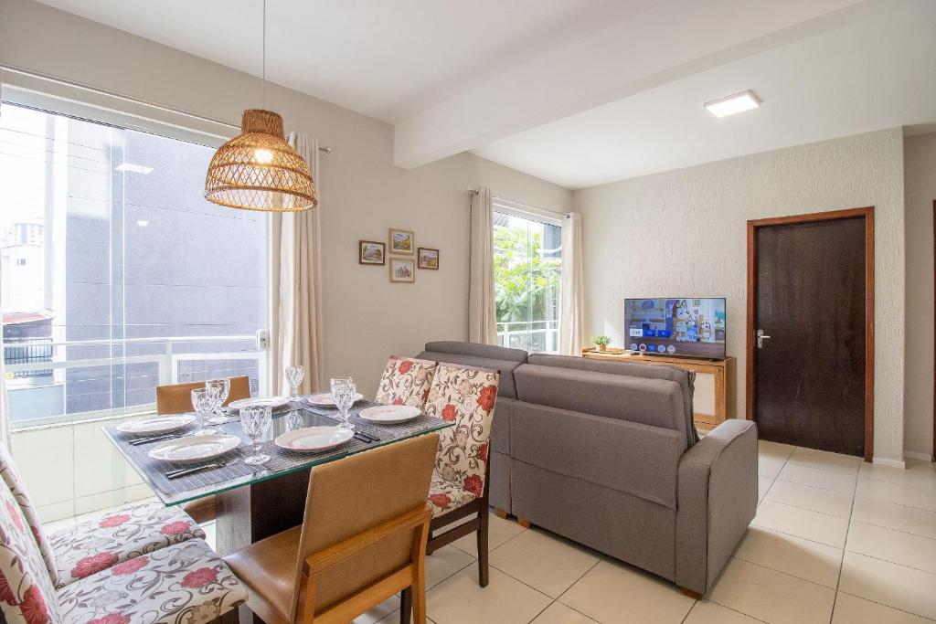 ein Wohnzimmer mit Couch und Tisch in der Unterkunft JOA31 - 2 Dorm Climatizados, Garagem, TV Smart in Balneário Camboriú