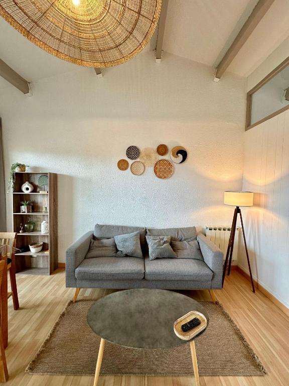 un salon avec un canapé et une table dans l'établissement L'Horizon bleu, au Barcarès