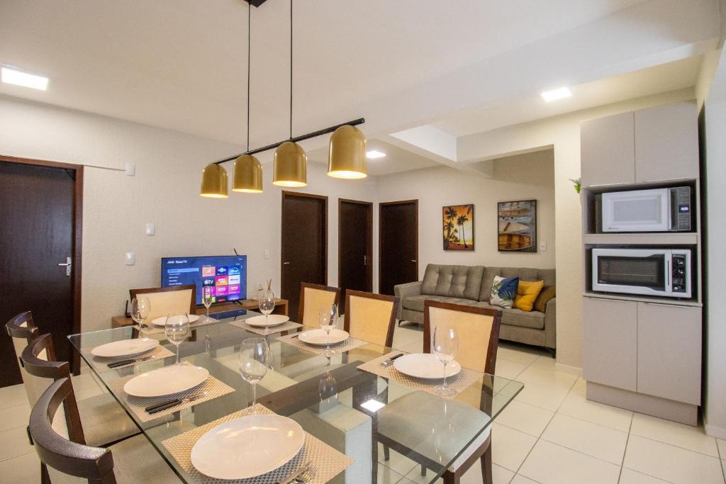 una sala da pranzo e un soggiorno con tavolo e sedie in vetro di JOA33 - 3 Dorm, Climatizado, Garagem a Balneário Camboriú