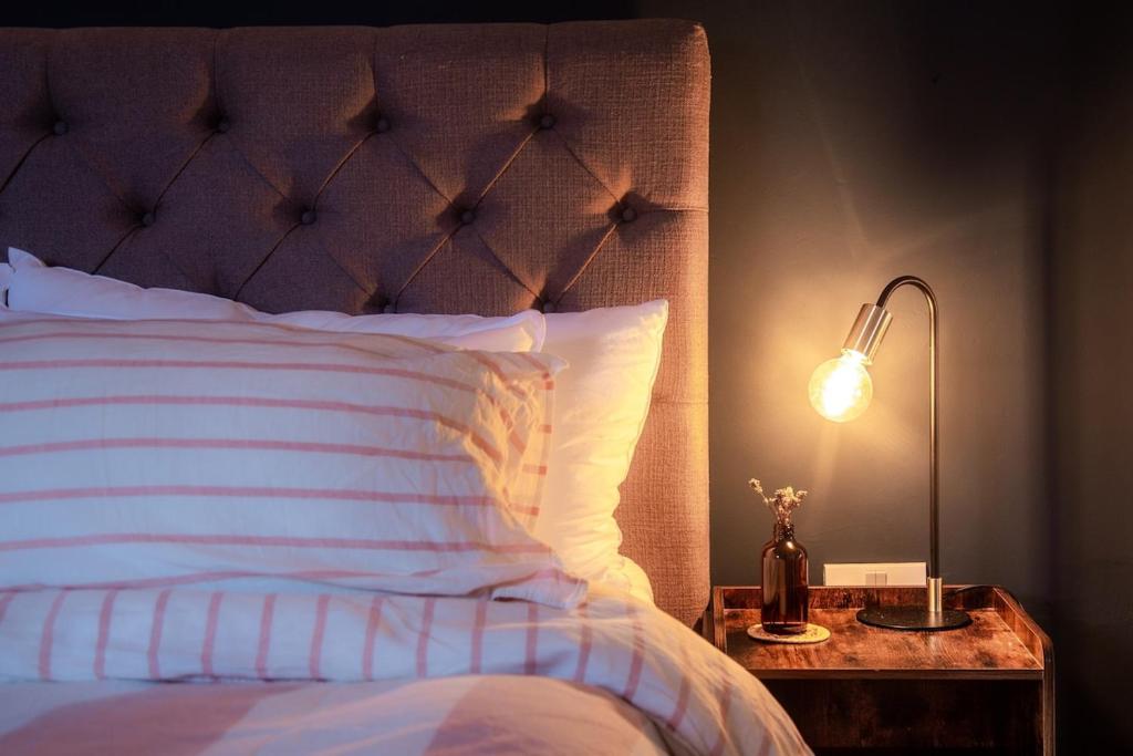 a bedroom with a bed and a lamp on a night stand at Stylish Padstow Townhouse in Padstow