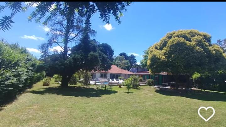 een huis met een tuin met een boom en een bank bij Casa Quinta con pileta Tortuguitas Bs As in Manuel Alberti