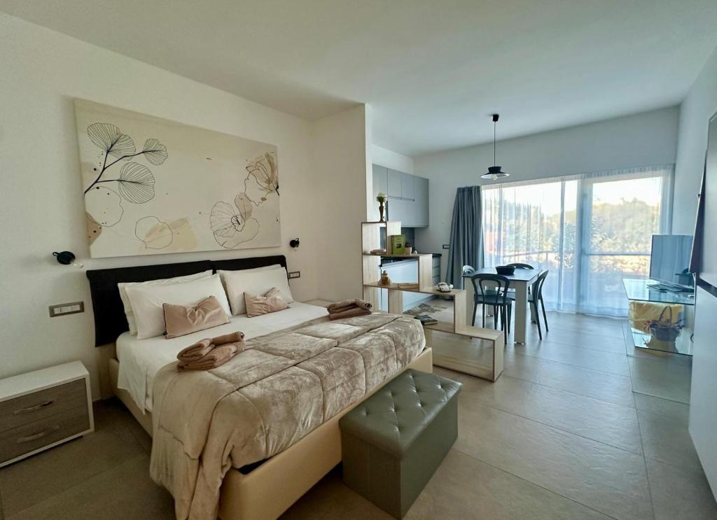 Un dormitorio con una cama grande y un comedor. en Blue Velvet Rooms, en Tortolì