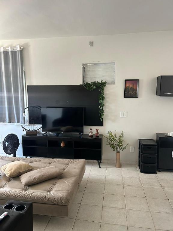 a living room with a bed and a desk at Cozy Kitnet on Costa Beach in Vila Velha