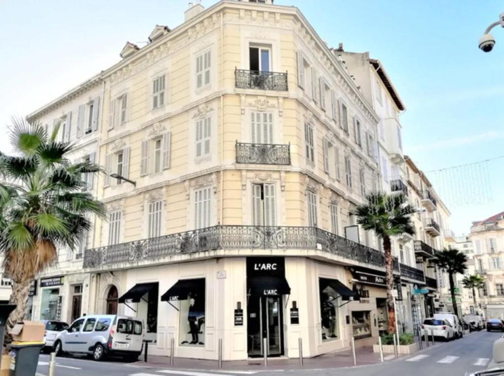 un grand bâtiment blanc au coin d'une rue dans l'établissement Lecerf Croisette, à Cannes