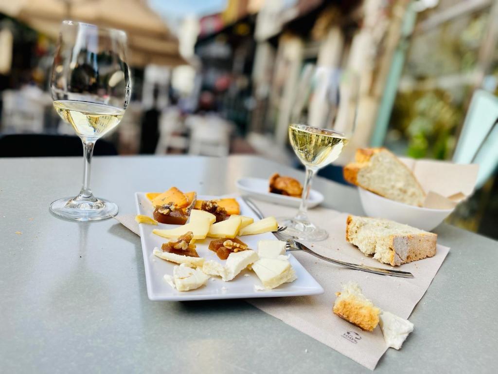 a plate of food and glasses of wine on a table at Apartamento Jardín de San Feliz / Fontán in Oviedo