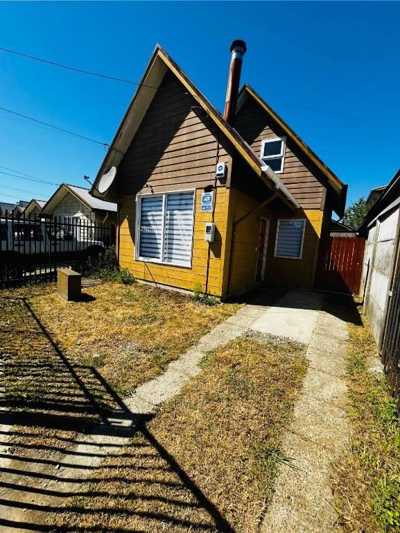 a yellow house with a fence in front of it at Casa 3 dormitorios acogedora se arrienda diario mínimo dos noches in Valdivia