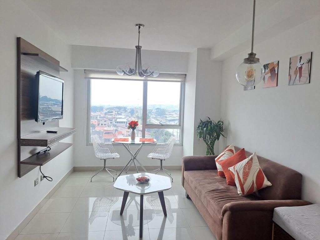 un soggiorno con un divano e un tavolo di AMBAR SUITE CON VISTA A LA CIUDAd a Guayaquil