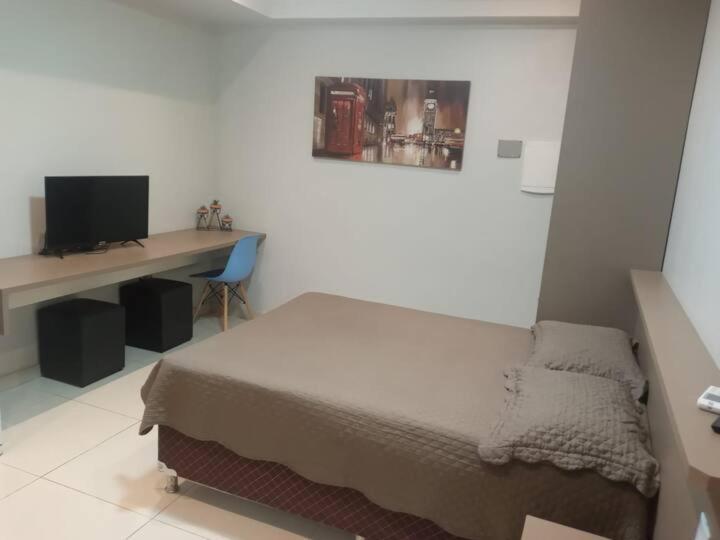 a bedroom with a bed and a desk with a computer at Studio Maraba-LOFT LINDO in Marabá